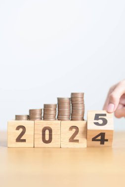 2024 'ün sonundaki mutlu yıllar 2025' e madeni paralarla. Para, Bütçe, vergi, yatırım, finans, tasarruf ve Yeni Yıl Çözüm kavramları