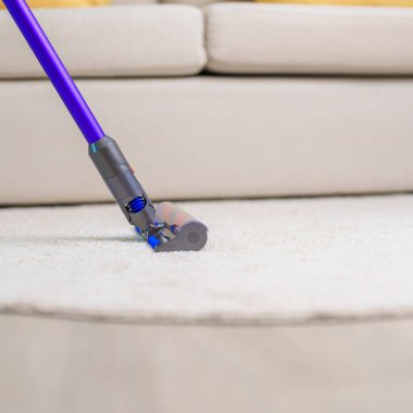 Halıyı kablosuz elektrik süpürgesiyle temizleyen kadın. Ev hanımı evi temizlemek için kablosuz süpürge kullanıyor. Ev işleri, Temizlik, Temizlik, Temizlik, Toz, Temizlik ve günlük rutin