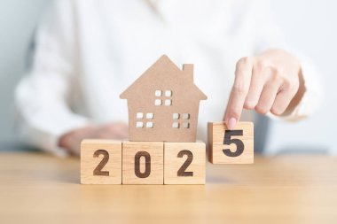 Ev modeliyle mutlu yıllar 2025. gayrimenkul, konut kredisi ve ipotek, vergi, yatırım, finans, tasarruf ve yeni yıl kararı kavramları