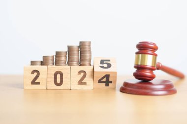 2024 'ün sonundaki yeni yıl 2025' e Yargıç tokmak ve para destesiyle. Hukuk maliyeti, avukat, yargı, adalet açık artırması ve teklif kavramları