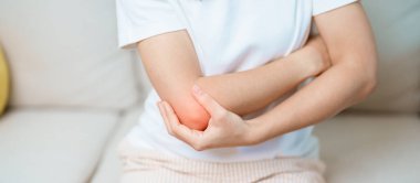 Kadının evinde dirsek ağrısı, yan epikondilit ya da tenis dirseği yüzünden kas ağrısı var. yaralanma, sağlık ve tıbbi konsept