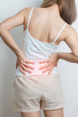 Evde sırt ağrısı çeken bir kadın. Piriforis Sendromu, bel ağrısı ve omurga baskısı nedeniyle kas ağrısı olan yetişkin bir kadın. Ofis sendromu ve tıbbi konsept