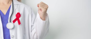 Aralık Dünya Yardım Günü için kırmızı kurdeleli doktor, bağışıklık yetmezliği sendromu, çoklu miyelom kanseri farkındalığı ayı ve Ulusal Kırmızı Kurdele haftası. Sağlık ve dünya kanser günü konsepti