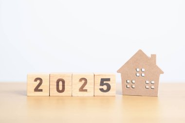 Ev modeliyle mutlu yıllar 2025. gayrimenkul, konut kredisi ve ipotek, vergi, yatırım, finans, tasarruf ve yeni yıl kararı kavramları