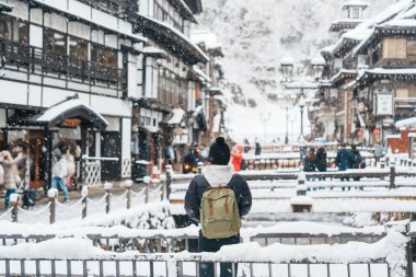 Yamagata 'da Ginzan Onsen' i ziyaret eden kadın turist, mutlu gezgin kış mevsiminde Snow ile Japon Onsen köyünü geziyor. Japonya 'da bir dönüm noktası ve popüler. Seyahat ve Tatil kavramı