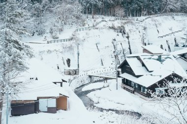 Beautiful view of Ginzan Onsen village with snow fall in winter season is most famous Japanese Hot Spring in Yamagata, Japan. clipart