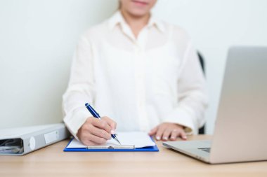 Bilgisayarlı bilgisayarda çalışan Asyalı kadın, okuma yazma kadın iş kadını ya da evrak klasörü ile evdeki ya da ofisteki sözleşme imzalayan. ticari finansal konsept