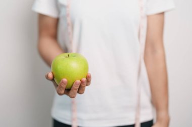 Kadın el ele tutuşan yeşil elma, mutlu kadın spor salonu meyve seçmek sağlıklı yemektir. Diyet kontrolü, kilo kaybı, obezite, yeme tarzı ve beslenme kavramları