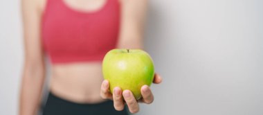 Kadın el ele tutuşan yeşil elma, mutlu kadın spor salonu meyve seçmek sağlıklı yemektir. Diyet kontrolü, kilo kaybı, obezite, yeme tarzı ve beslenme kavramları