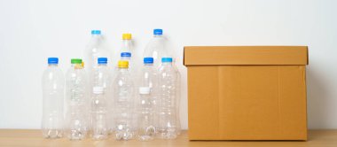 Evdeki ya da ofisteki karton kutuda plastik şişe. Çöpü geri dönüşüm sıralaması. Plastiksiz, Ekoloji, Çevre, Kirlilik, Geri dönüşüm, Atık Yönetimi ve Çöp Ayırma Konsepti