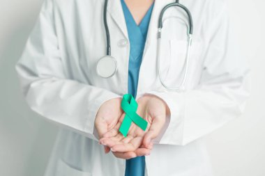 Doctor holding Teal Ribbon for January Cervical Cancer Awareness month. Uterus and Ovaries, Cervix, Endometriosis, Hysterectomy, Uterine fibroids, Reproductive, Healthcare and World cancer day clipart