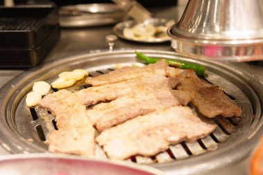 Lokantada ocakta domuz eti ızgara. Kore yemekleri ve geleneksel barbekü tarzı.