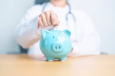 Doktor kumbarayı tutuyor ve para koyuyor. ve sağlık giderleri, para tasarrufu, sağlık sigortası, sağlık, bağış ve finansal kavramlar
