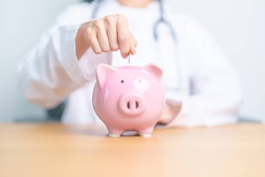 Doktor kumbarayı tutuyor ve para koyuyor. ve sağlık giderleri, para tasarrufu, sağlık sigortası, sağlık, bağış ve finansal kavramlar
