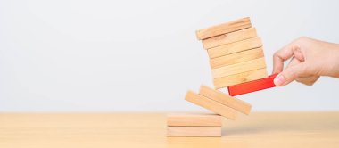 Kadın eli masadaki tahta domino taşlarını çekiyor. Kriz, Sonbahar İşletmeleri, Risk Yönetimi, Ekonomik durgunluk, Strateji ve Çözümler Konsepti