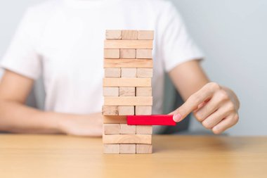 Elle çekilen tahta blok kulesi masanın üzerinde. İş planlaması, Risk Yönetimi, Çözüm, lider, strateji, kriz, düşen iş ve ekonomik durgunluk kavramı