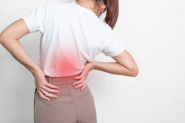 Gri arka planda kas ağrısı olan yetişkin bir kadın. Piriforis Sendromu, bel ağrısı ve omurga baskısı nedeniyle sırt ağrısı çeken yaşlı bir kadın. Ofis sendromu ve tıbbi konsept