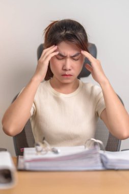 Kadın iş kadınının başı ağrıyor, migreni var, Asyalı kadının çalışırken yorgun ve stresli olması, gece yarısı evde evrak klasörleri olan bitkin bir kadın. Fazla çalışma ve fazla mesai