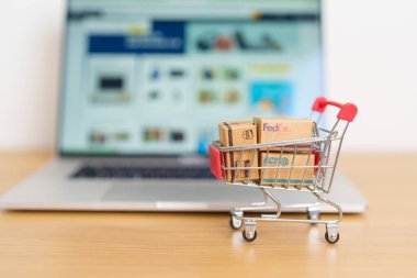 Nakliye kutuları dizüstü bilgisayarda. Dünya çapında popüler nakliye ve lojistik şirketi, Amazon, DHL, FedEx, UPS ve OCS ekspres çevrimiçi alışveriş. Bangkok, Tayland, 11 Haziran 2023