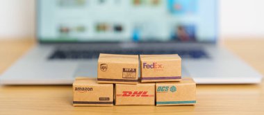 Shipping Boxes on laptop. Popular worldwide shipping and logistic company, Amazon, DHL, FedEx, UPS and OCS express delivery from online shopping. Bangkok, Thailand, 11 June 2023 clipart