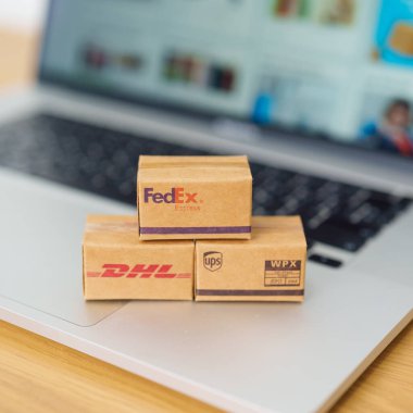 Nakliye kutuları dizüstü bilgisayarda. Dünya çapında popüler nakliye ve lojistik şirketi, Amazon, DHL, FedEx, UPS ve OCS ekspres çevrimiçi alışveriş. Bangkok, Tayland, 11 Haziran 2023
