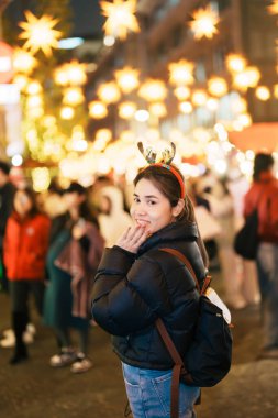 Mutlu turist kadın bir Alman Noel pazarında duruyor. Mutlu Noeller, bayramlar ve mutlu yıllar konsepti