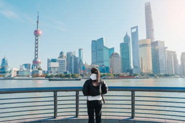 Çin, Şangay 'ı ziyaret eden bir kadın gezgin. Sırt çantalı bayan turist Şangay 'da Lujiazui' nin Şangay manzarasına bakıyor. Şehir simgesi ve turizm turizmi için popüler. Tatil kavramı