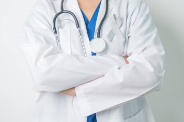 Beyin Kanseri Farkındalığı Mayıs ayında, gri renkli kurdeleli doktor, yaşam insanlarını desteklediği için. Sağlık ve Dünya Kanser Günü konsepti