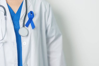 March Colectal Kanser Farkındalığı Ayı. Koyu mavi kurdeleli bir doktor. Yaşayan ve hastalıklı insanları destekliyor. Sağlık, umut ve Dünya Kanser Günü konsepti