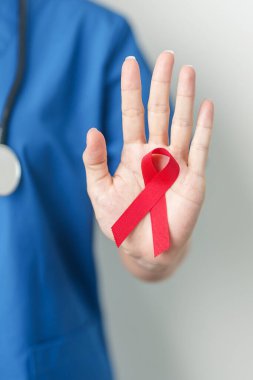 Aralık Dünya Yardım Günü için kırmızı kurdeleli doktor, bağışıklık yetmezliği sendromu, çoklu miyelom kanseri farkındalığı ayı ve Ulusal Kırmızı Kurdele haftası. Sağlık ve dünya kanser günü konsepti