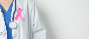 Pembe Ekim Göğüs Kanseri Bilinci Ayı, Pembe Kurdeleli kadın doktor, insanların hayatını ve hastalıklarını desteklemek için hastanede. Ulusal Kanserden kurtulanlar ayı, Anne ve Dünya Kanser Günü konsepti