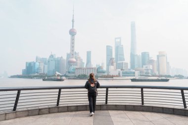 Çin, Şangay 'ı ziyaret eden bir kadın gezgin. Sırt çantalı bayan turist Şangay 'da Lujiazui' nin Şangay manzarasına bakıyor. Şehir simgesi ve turizm turizmi için popüler. Tatil kavramı