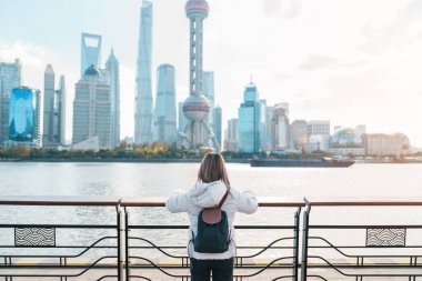 Çin, Şangay 'ı ziyaret eden bir kadın gezgin. Sırt çantalı bayan turist Şangay 'ın kuzeyindeki Lujiazui' nin Şangay manzarasına bakıyor. tarihi eser ve turizm turizmi için popüler.