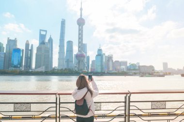 Çin, Şangay 'ı ziyaret eden bir kadın gezgin. Sırt çantalı bayan turist Şangay 'ın kuzeyindeki Lujiazui' nin Şangay manzarasına bakıyor. tarihi eser ve turizm turizmi için popüler.