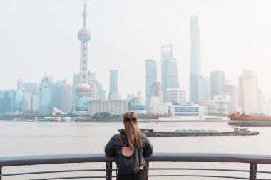 Çin, Şangay 'ı ziyaret eden bir kadın gezgin. Sırt çantalı bayan turist Şangay 'da Lujiazui' nin Şangay manzarasına bakıyor. Şehir simgesi ve turizm turizmi için popüler. Tatil kavramı
