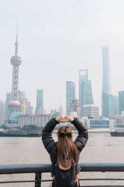 Çin, Şangay 'ı ziyaret eden bir kadın gezgin. Sırt çantalı bayan turist Şangay 'da Lujiazui' nin Şangay manzarasına bakıyor. Şehir simgesi ve turizm turizmi için popüler. Tatil kavramı