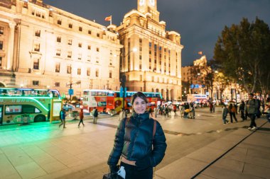 Çin, Şangay 'ı ziyaret eden bir kadın gezgin. Şangay 'ın Bund of Shanghai bölgesini gezerken mutlu bayan turistler. Şehir simgesi ve turizm turizmi için popüler. Seyahat ve Tatil kavramı