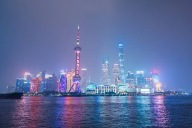 Gece Şangay şehrinin şehir manzarası. Pudong 'daki Lujiazui' nin gökdeleni, Çin 'in Şangay Bund' ından manzara. Şehir simgesi ve turizm turizmi için popüler. Seyahat ve Tatil kavramı