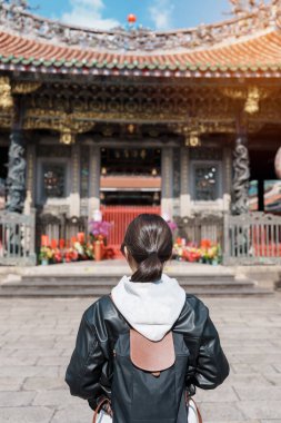 woman traveler visiting in Taiwan, female Tourist sightseeing at Longshan Temple, Chinese folk religious temple in Wanhua District, Taipei City. landmark and popular. Travel and Vacation concept clipart