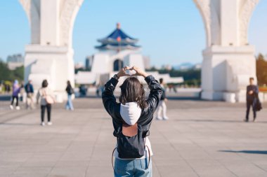 woman traveler visiting in Taiwan, female Tourist sightseeing at National Chiang Kai shek Memorial or Hall Freedom Square, Taipei City. Popular landmark and attractions. Asia Travel concept  clipart