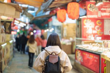 Tayvan 'da gezgin bir kadın, sırt çantalı bir turist Jiufen Old Street pazarını geziyor ve alışveriş yapıyor. Taipei şehrinin yakınlarındaki popüler bir yer ve eğlence merkezi. Seyahat ve Tatil kavramı