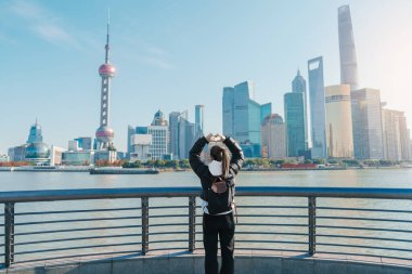 Çin, Şangay 'ı ziyaret eden bir kadın gezgin. Sırt çantalı bayan turist Şangay 'da Lujiazui' nin Şangay manzarasına bakıyor. Şehir simgesi ve turizm turizmi için popüler. Tatil kavramı