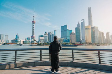 Şangay, Çin 'i ziyaret eden bir gezgin. Erkek turist Şangay 'da Lujiazui' nin The Bund of Shanghai manzarasını seyrediyor. Şehir simgesi ve turizm turizmi için popüler. Tatil kavramı