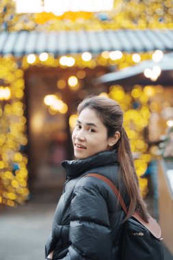 woman traveler visiting in Shanghai, China. Female Tourist with backpack sightseeing in Xintiandi at night. landmark and popular for tourism attractions in Shanghai. Travel and vacation concept  clipart