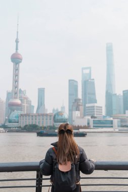 Çin, Şangay 'ı ziyaret eden bir kadın gezgin. Sırt çantalı bayan turist Şangay 'da Lujiazui' nin Şangay manzarasına bakıyor. Şehir simgesi ve turizm turizmi için popüler. Tatil kavramı