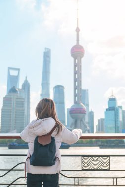 Çin, Şangay 'ı ziyaret eden bir kadın gezgin. Sırt çantalı bayan turist Şangay 'ın kuzeyindeki Lujiazui' nin Şangay manzarasına bakıyor. tarihi eser ve turizm turizmi için popüler.
