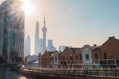 woman traveler visiting in Shanghai, China. Female Tourist with backpack sightseeing Shanghai view of Lujiazui in Hongkou Gang canal of Shanghai. landmark and popular for tourism attraction clipart