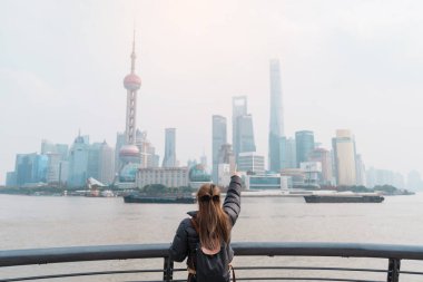 Çin, Şangay 'ı ziyaret eden bir kadın gezgin. Sırt çantalı bayan turist Şangay 'da Lujiazui' nin Şangay manzarasına bakıyor. Şehir simgesi ve turizm turizmi için popüler. Tatil kavramı