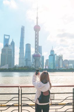 Çin, Şangay 'ı ziyaret eden bir kadın gezgin. Sırt çantalı bayan turist Şangay 'ın kuzeyindeki Lujiazui' nin Şangay manzarasına bakıyor. tarihi eser ve turizm turizmi için popüler.