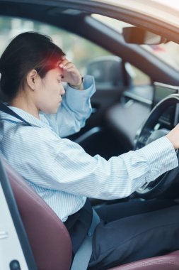 Araba kullanırken gergin ve sinirli bir kadın. Asyalı kız trafikte araba kullandıktan sonra yorgun ve yorgun düşüyor. Uykulu, esnetici ve sarhoş konsepti